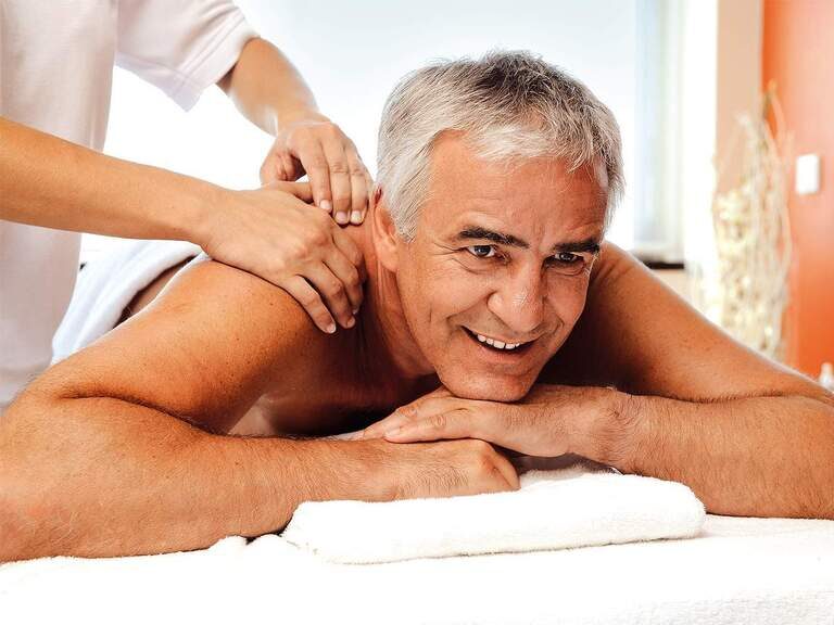 Ein Mann erhält eine wohltuende Massage im Wellnessbereich vom Johannesbad in Bad Füssing.